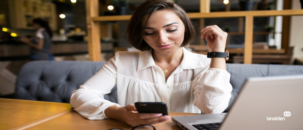 Mujer mirando un móvil, representando la participación de Lanalden en el proyecto Deliveron con Inteligencia Artificial para mejorar la experiencia post-venta.