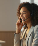 Agente sonriente trabajando en contact center Madrid, representando eficiencia y atención profesional en cada interacción con el cliente.